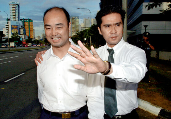 2004年12月,陈久霖在新加坡警方人员的陪同下离开警察局,此前他被新加坡警方拘留。